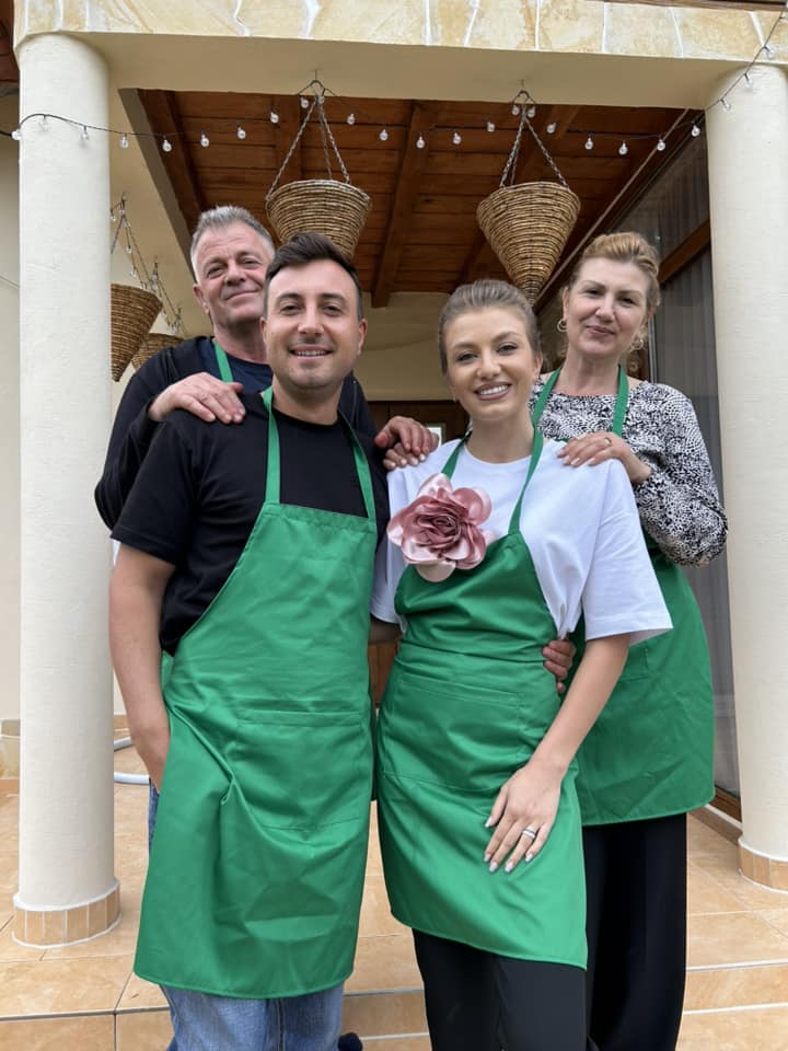 Valentin Sanfira și Codruța Filip alături de părinții artistei, &icirc;n casa acestora, &icirc;n timp ce purtau toți șorțuri de bucătărie verzi și găteau &icirc;mpreună