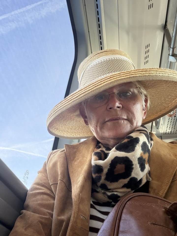 Monica Tatoiu făc&acirc;ndu-și un selfie, &icirc;n timp ce era &icirc;mbrăcată &icirc;ntr-o geacă maro de piele &icirc;ntoarsă, cu eșarfă animal print la g&acirc;t și cu pălărie pe cap