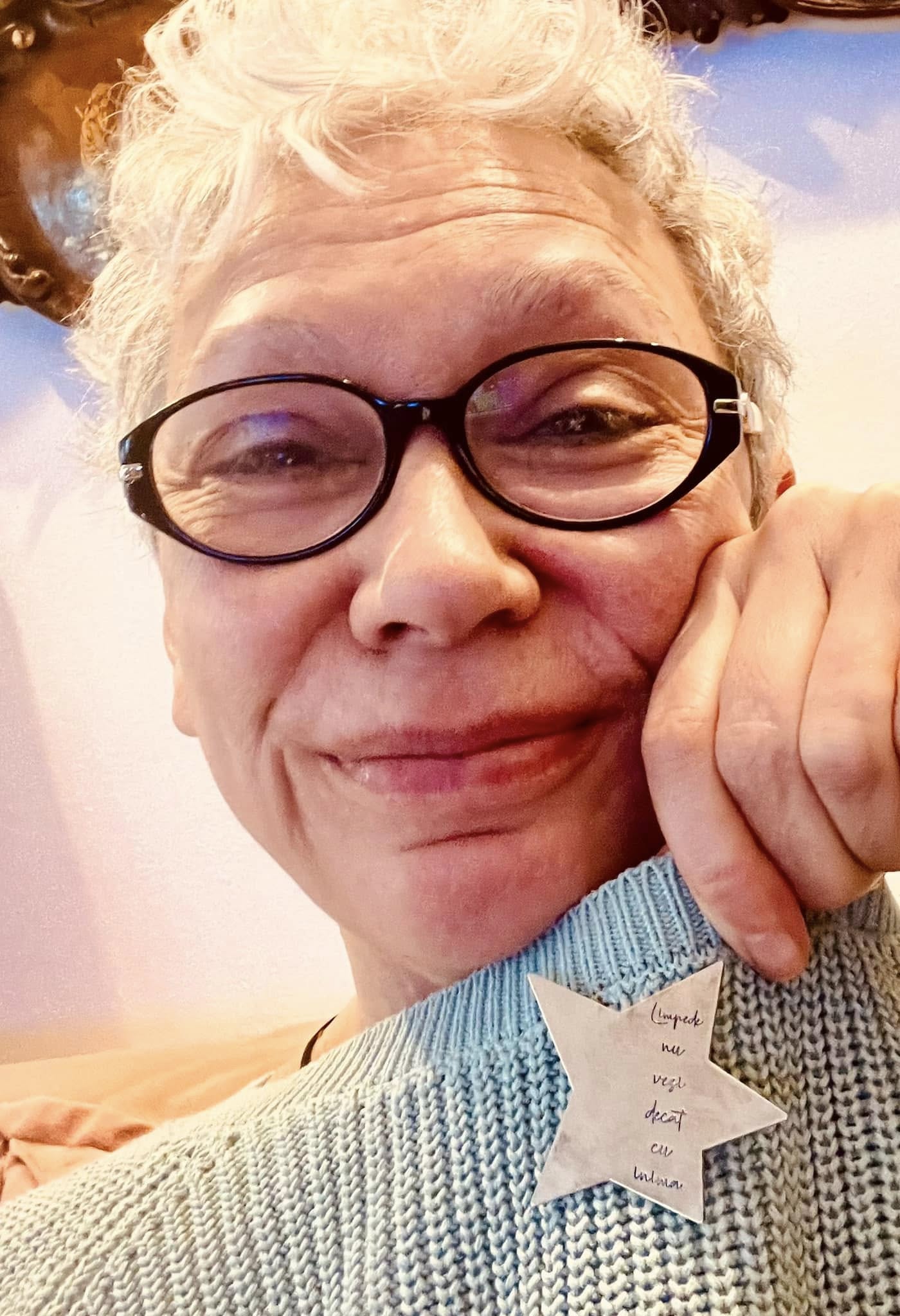 Oana Pellea z&acirc;mbitoare, făc&acirc;ndu-și un selfie cu o insignă &icirc;n formă de stea, prinsă pe un pulover bleu