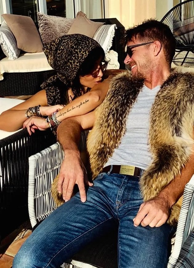 Mihaela Rădulescu sprijinindu-se pe m&acirc;na lui Felix Baumgartner, care este la r&acirc;ndul ei sprijinită de m&acirc;nerul unui fotoliu pe care parașutistul stătea la soare, &icirc;n blugi, maoiu și vestă de blană