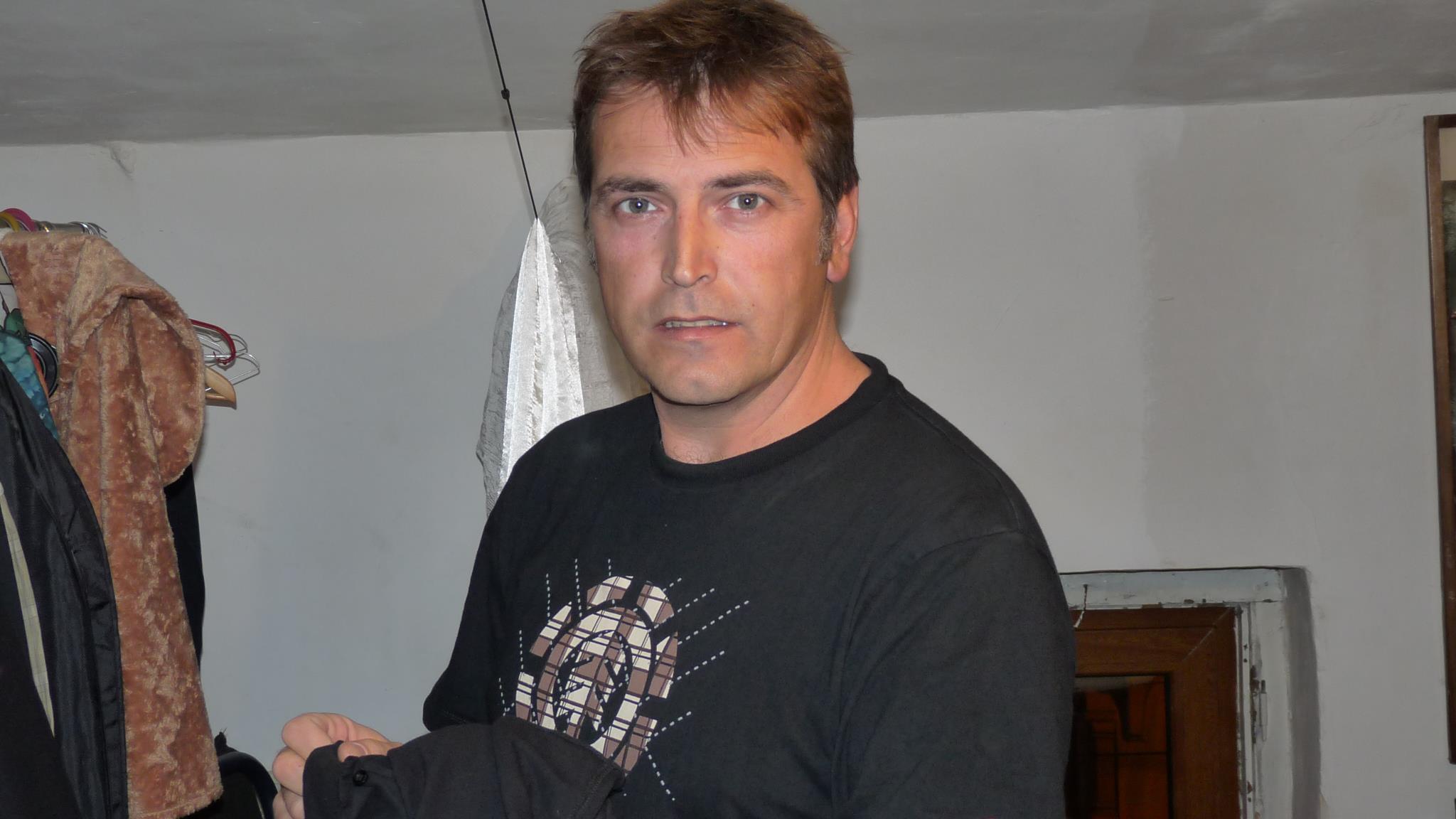 Ioan Isaiu, &icirc;n culise, la teatru, printre costume, &icirc;n timp ce el purta o bluză &icirc;nchisă la culoare cu imprimeu pe piept