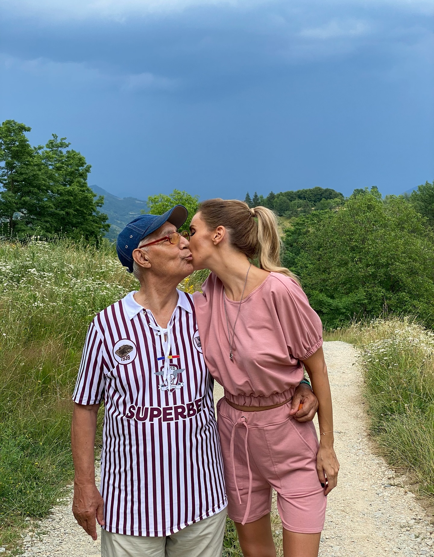 Ana Maria Pavel, soția lui Daniel Pavel, alături de tatăl acestuia, pe care &icirc;l &icirc;mbrățișează și &icirc;l sărută pe obraz, &icirc;n timpul unei plimbări prin natură