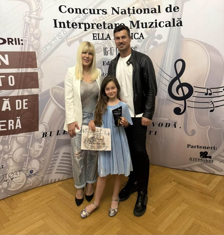 Elena Udrea și Adrian Alexandrov alături de fiica lor, Eva Maria, la un concurs de muzică pe care l-a și c&acirc;știgat și &icirc;n urma căruia a primit trofeu și diplomă pe care le ținea m&acirc;ndră &icirc;n m&acirc;ini &icirc;n momentul realizării fotografiei