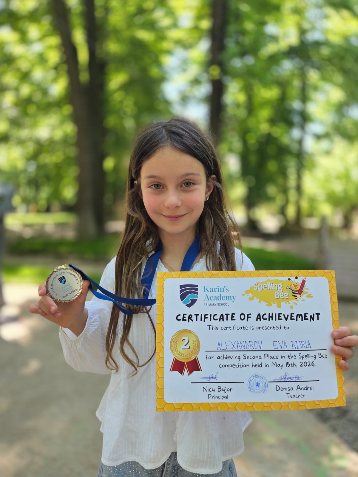 Eva Maria, fiica Elenei Udrea, țin&acirc;nd &icirc;n m&acirc;ini diploma și medalia primite &icirc;n urma participării la un concurs