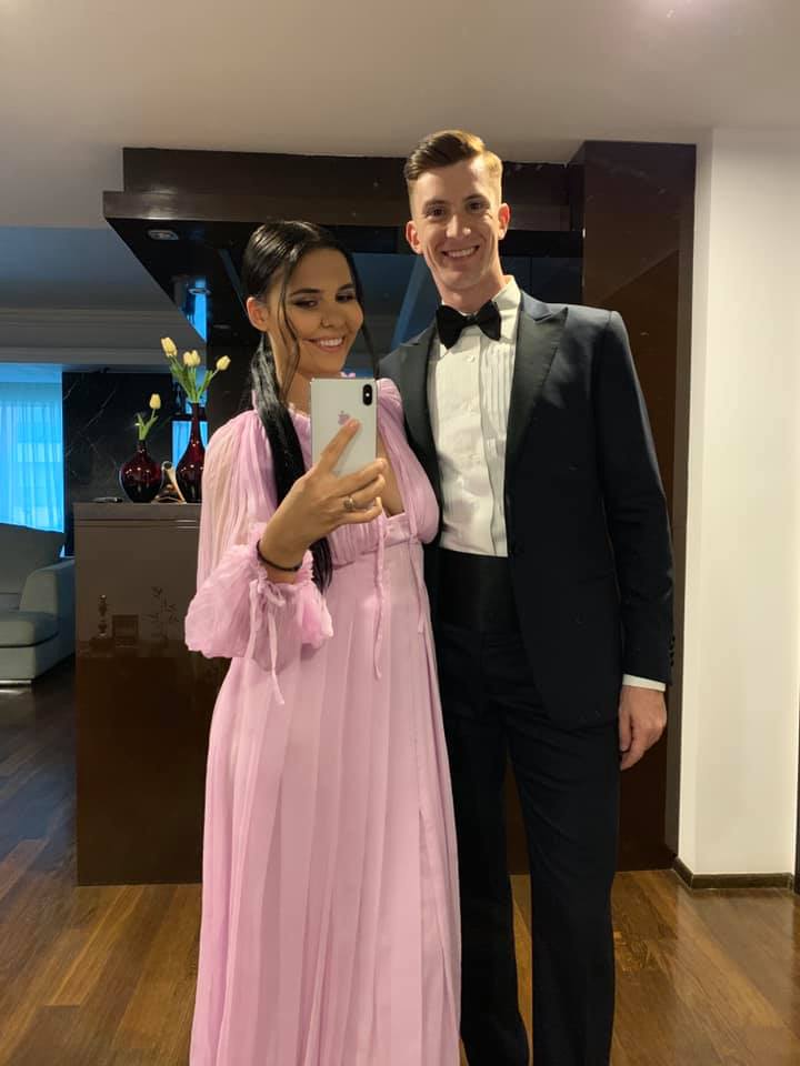 Andreea Popescu și Rareș Cojoc făc&acirc;ndu-și o fotografie &icirc;n oglindă, &icirc;mbrăcați elegant, ea &icirc;n rochie lila și el &icirc;n costum negru, &icirc;n timp ce se pregăteau să meargă la un eveniment.