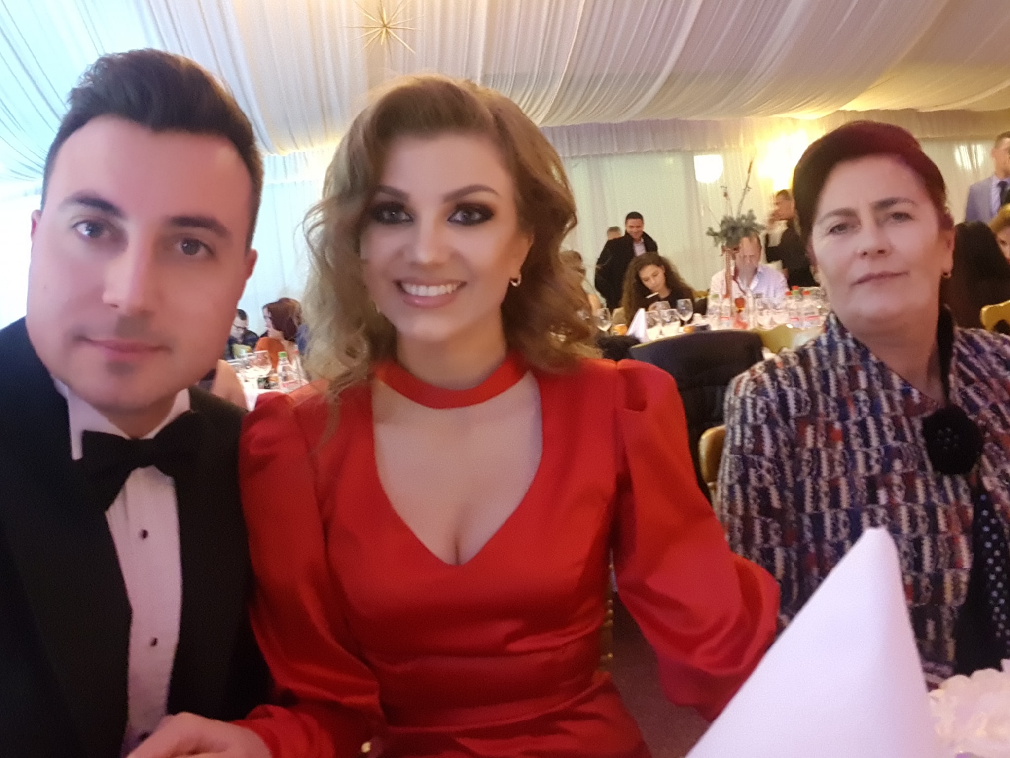 Valentin Sanfira &icirc;n costum elegant, st&acirc;nd la masă alături de fosta soție, &icirc;mbrăcată &icirc;n rochie roșie și de mama lui, &icirc;mbrăcată &icirc;ntr-un costum cu imprimeu colorat