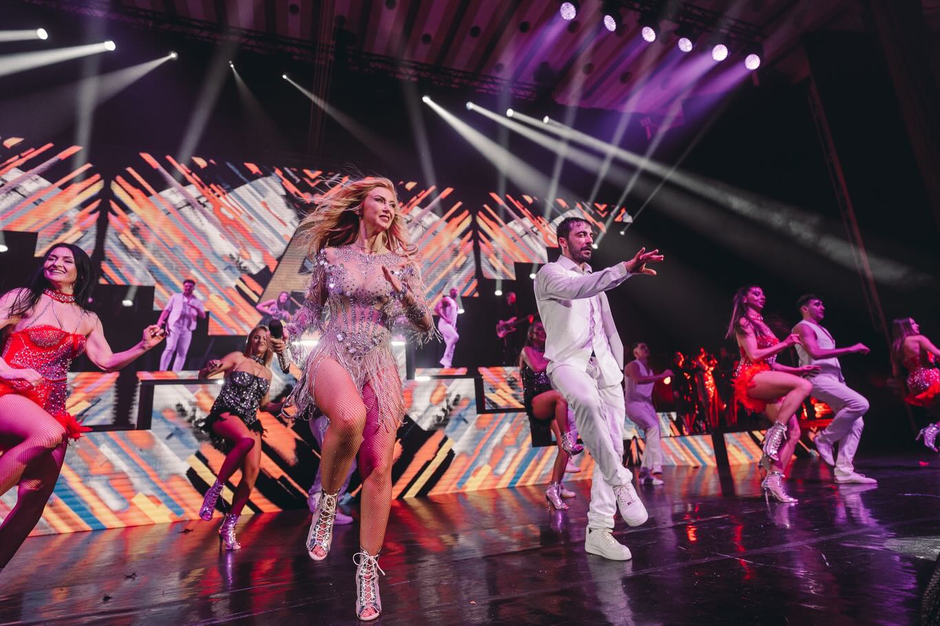 Andreea Bălan și Petrișor Ruge pe scenă, &icirc;nconjurați de lumini colorate și de alți colegi din trupa lor, &icirc;n timp ce erau toți &icirc;mbrăcați &icirc;n costumele de scenă