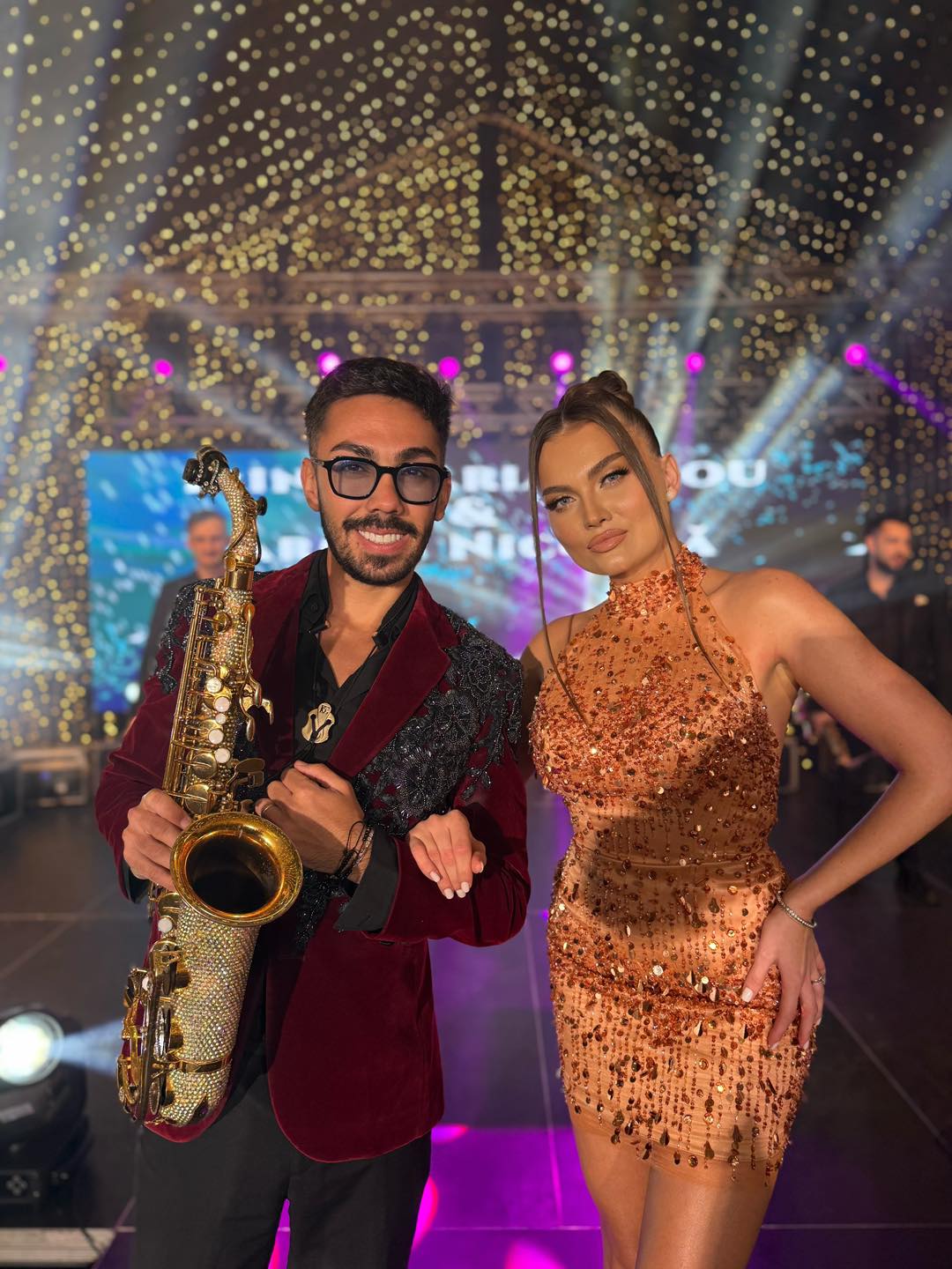 Armin Nicoară cu saxofonul &icirc;n m&acirc;nă, av&acirc;nd-o la braț pe colega sa de breaslă, Irina Maria Birou, &icirc;mbrăcată &icirc;ntr-o rochie scurtă cu paiete