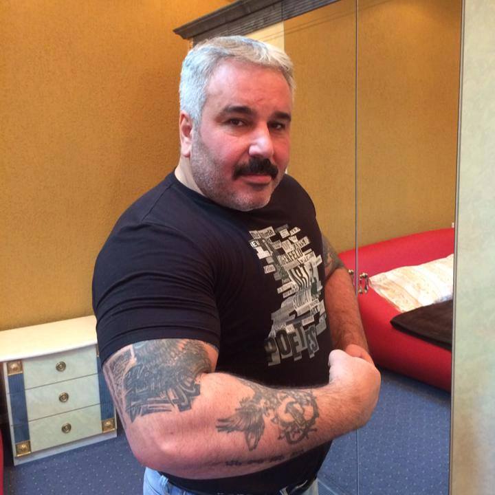 Sile Cămătaru &icirc;n blugi și &icirc;ntr-un tricou negru, arăt&acirc;nd-și mușchii &icirc;n fața camerei de fotografiat