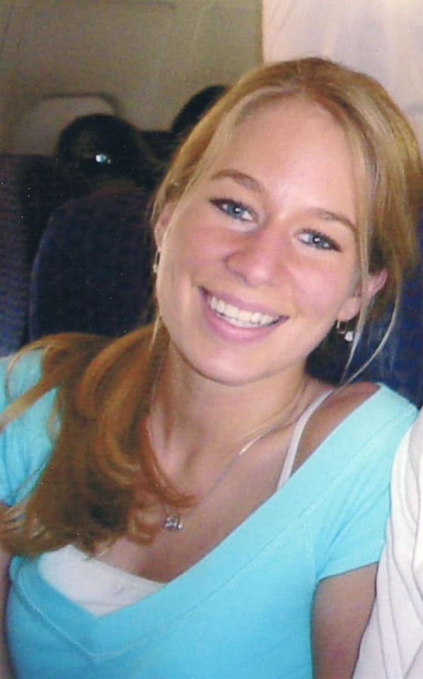 Natalee Holloway z&acirc;mbitoare, &icirc;ntr-un tricou bleu, cu bustieră albă pe dedesubt, care se vede &icirc;n zona decolteului