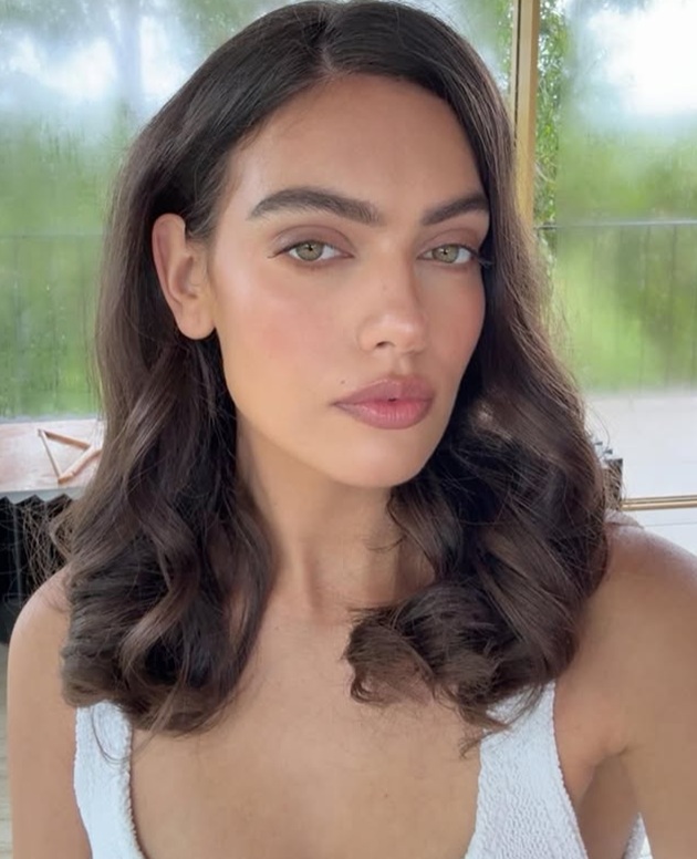 Claudia Dumitru făc&acirc;ndu-și un selfie &icirc;n timp ce purta un maiou alb și era machiată natural, cu părul coafat sub formă de bucle lejere