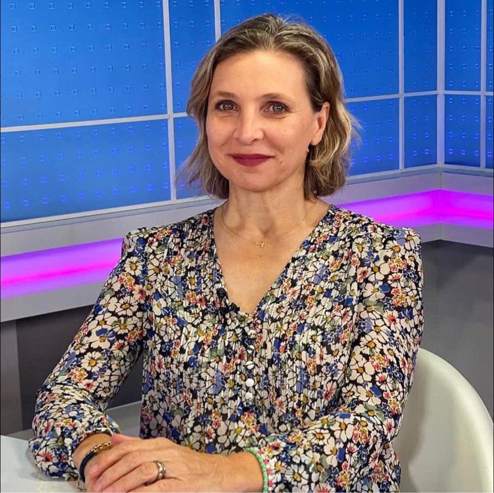 Daniela Silivaș st&acirc;nd pe scaun, &icirc;ntr-un studio TV, &icirc;mbrăcată &icirc;ntr-o rochie colorată cu imprimeu floral