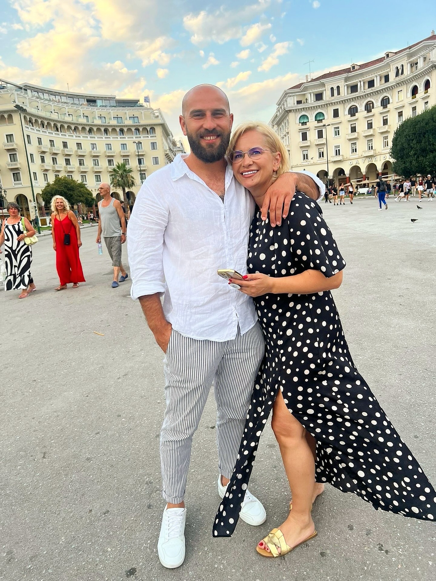 Paula Chirilă &icirc;ntr-o rochie lungă cu buline, st&acirc;nd &icirc;n brațele iubitului ei, &icirc;mbrăcat &icirc;n alb, &icirc;n timpul unei vacanțe