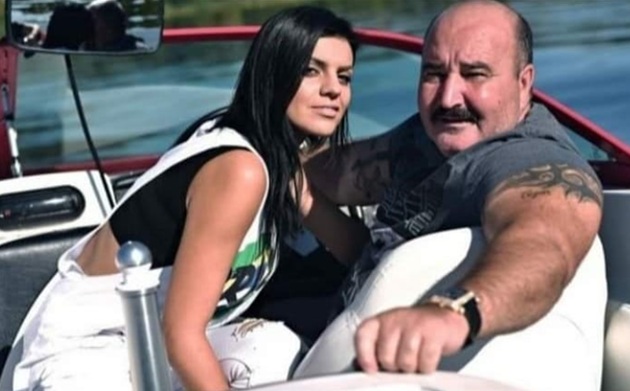 Nuțu Cămătaru &icirc;ntr-un tricou gri, pe o barcă, alături de Claudia Balint, cea de-a doua soție, &icirc;mbrăcată &icirc;n salopetă albă și tricou negru