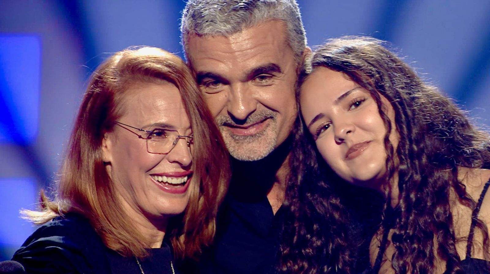 Aurelian Temișan cuprins &icirc;n brațe de soția sa, Monica Davidescu și de fiica lor, Dora, &icirc;n timp ce erau toți trei emoționați, pe scenă