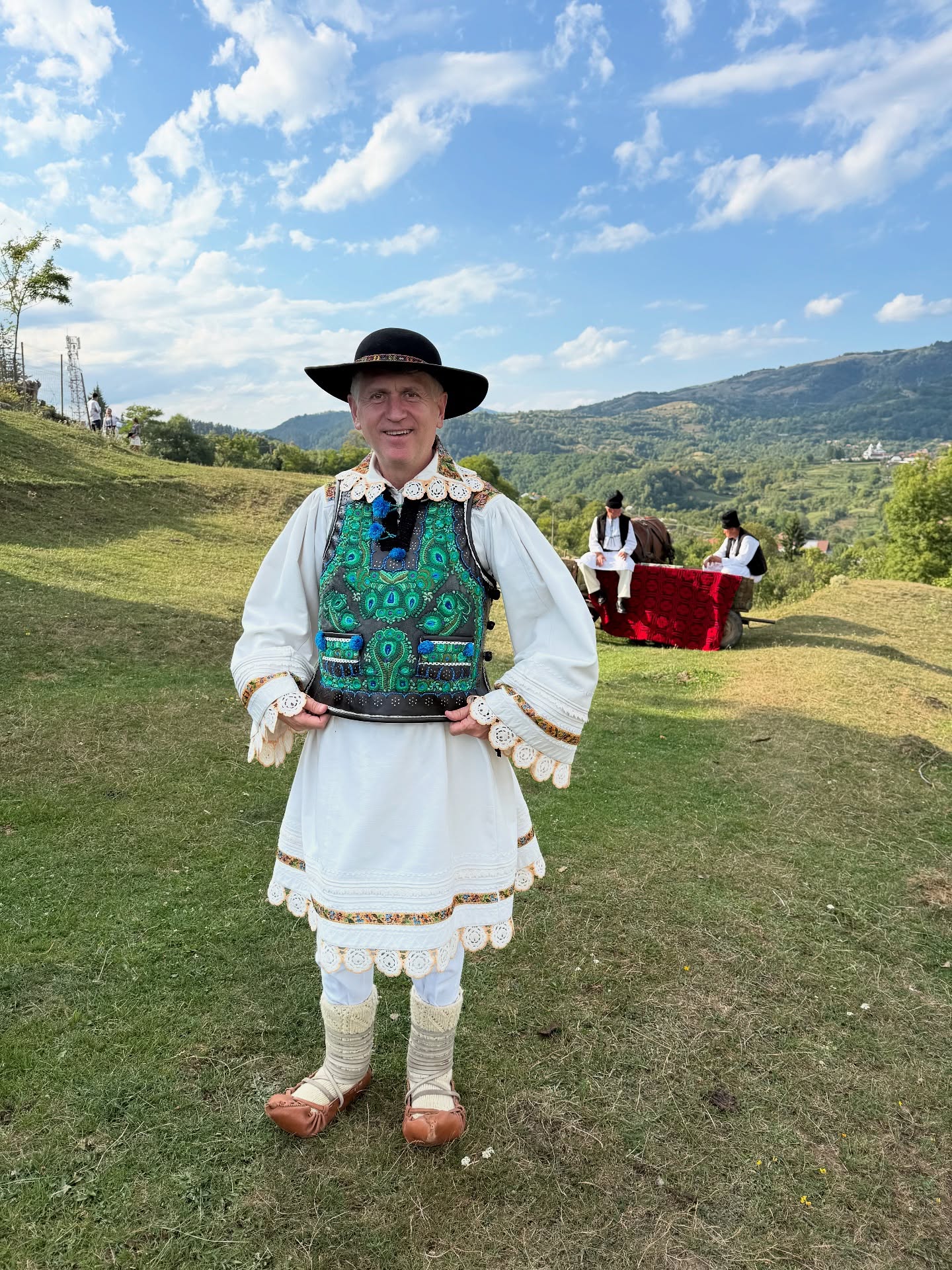 Cristian Pomohaci &icirc;n costum popular, pe un deal, alături de alți bărbați &icirc;mbrăcați &icirc;n straie populare