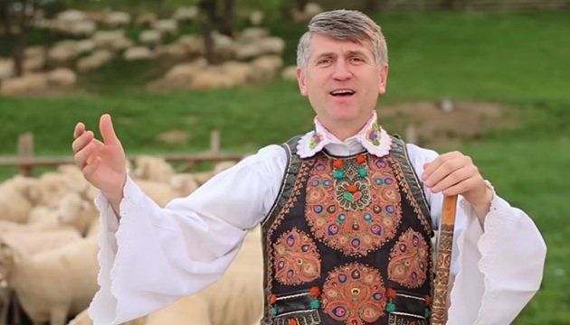 Cristian Pomohaci &icirc;n costum popular, c&acirc;nt&acirc;nd, &icirc;n timp ce filma pentru unul dintre videoclipurile pieselor sale.
