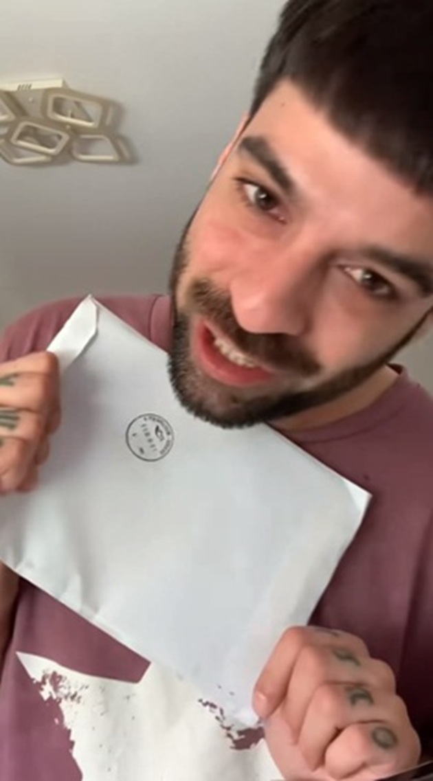 David Pușcaș zâmbitor, ținând în mâini decizia autorităților cu privire la procesul de hărțuire și amenințare deschis de mama lui adoptivă împotriva sa