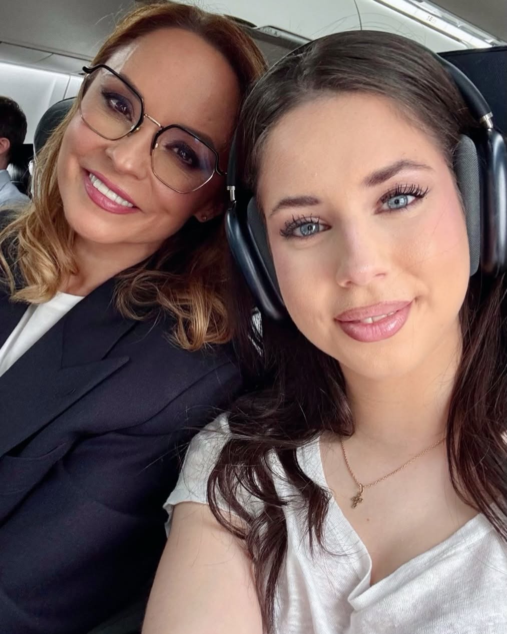 Andreea Marin și Violeta Bănică în avion, mama purtând ochelari de vedere la ochi, iar fiica purtând căști pe urechi