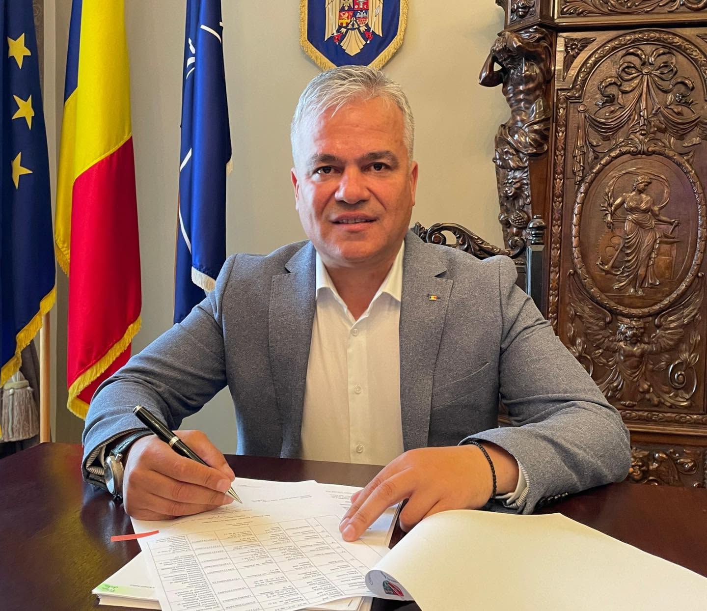 Adrian&nbsp;Veștea, noul premier desemnat al Rom&acirc;niei, st&acirc;nd &icirc;n birou, cu stiloul &icirc;n m&acirc;nă, &icirc;n timp ce semna niște acte și era &icirc;mbrăcat &icirc;ntr-un sacou gri cu cămașă albă