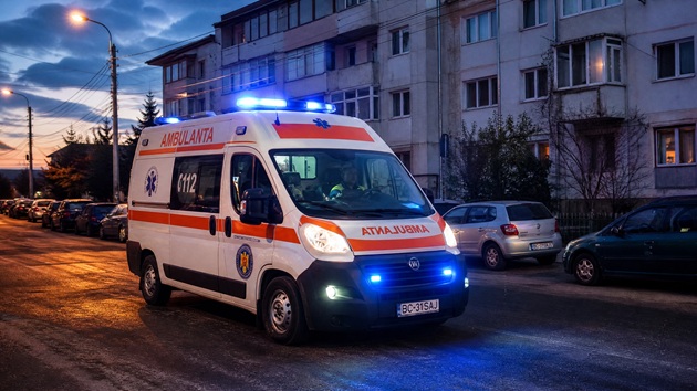 Ambulanță cu semnalele luminoase aprinse, mergând prin oraș, în timpul unei misiuni