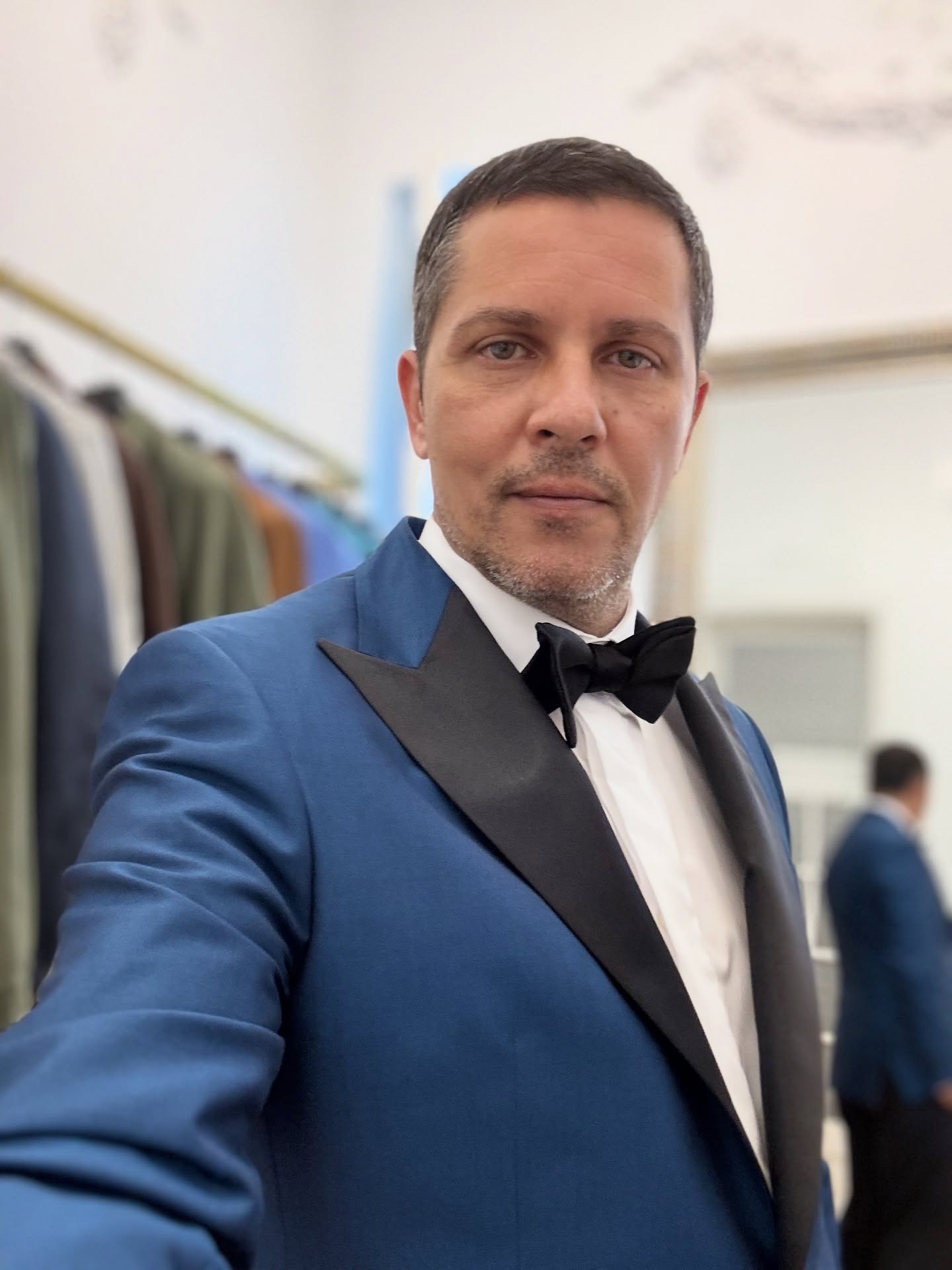 Lucian Viziru făcându-și un selfie în costum albastru închis, cu rever negru, papion negru și cămașă albă