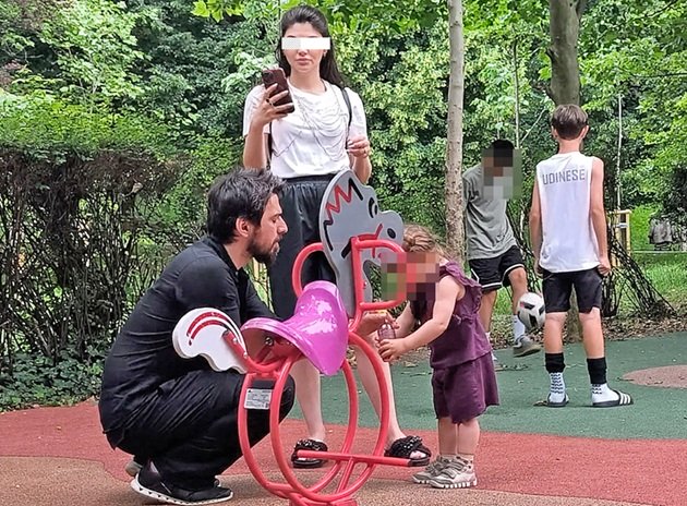 Tuncay&nbsp;Ozturk alături de partenera sa și de fiica lor, &icirc;n parc, la locul de distracții, oferindu-i celei mici să bea dintr-o sticlă cu suc, &icirc;n timp ce mama ei se uita atentă &icirc;n telefon