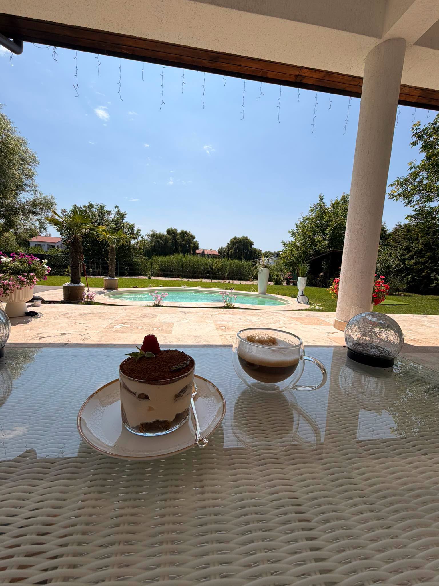 Cafeaua și prăjitura savurate de Valentin Sanfira pe terasa din curtea casei pe care a împărțit-o cu fosta soție, Codruța Filip, în timp ce în fundal se văd piscina, gazonul și florile