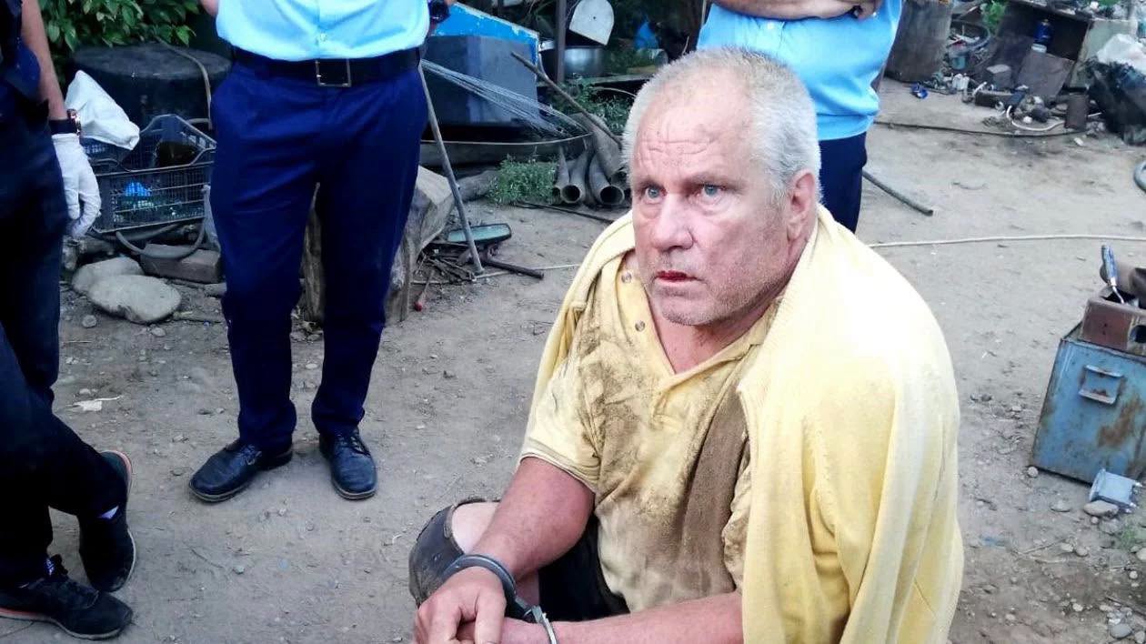 Gheorghe Dincă &icirc;nconjurat de polițiști, &icirc;ncătușat, murdar și cu hainele rupte