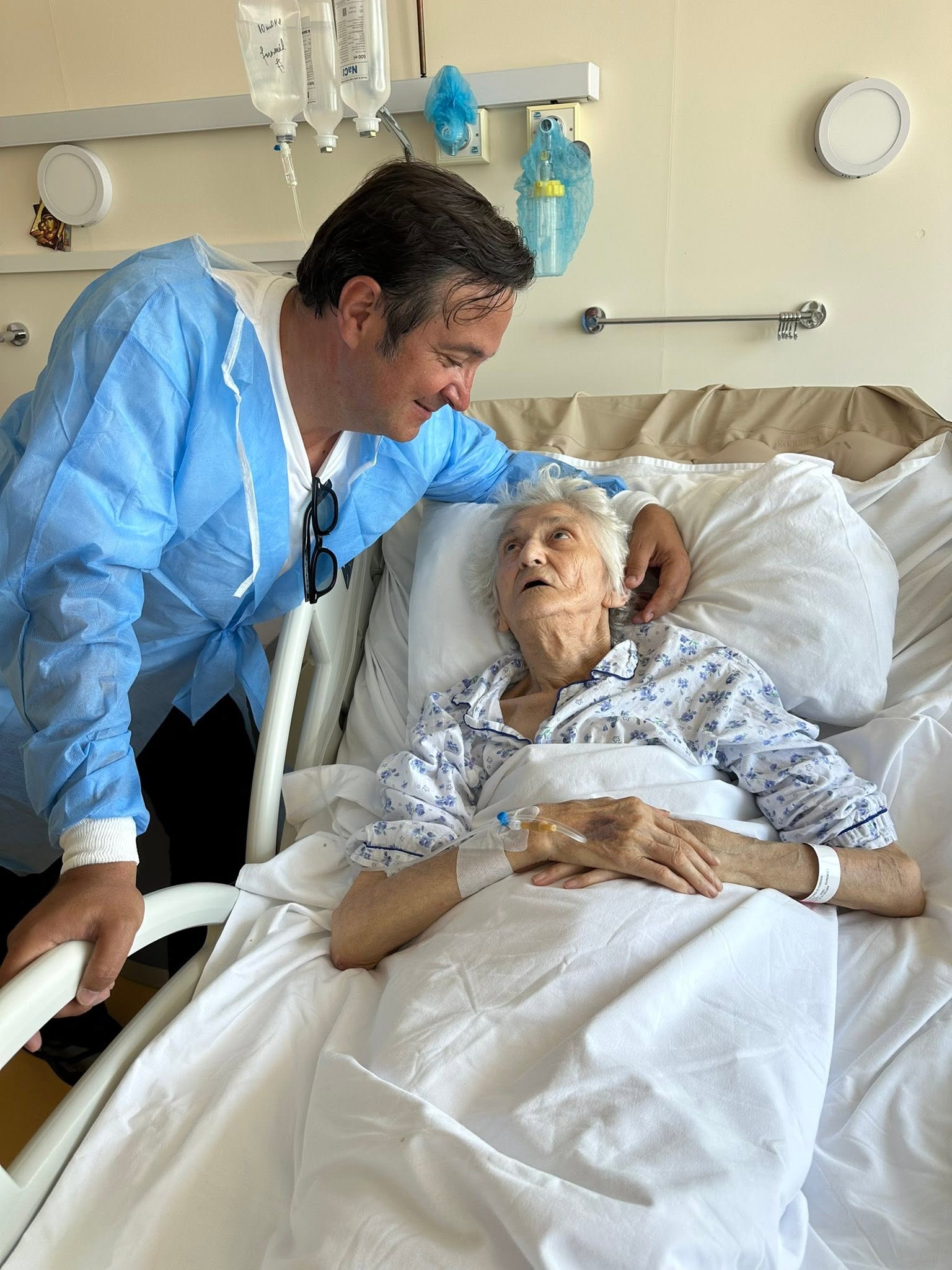 Daniel Buzdugan alături de mama sa, &icirc;n timp ce aceasta se afla pe patul de spital, iar el o privea &icirc;n ochi și o m&acirc;ng&acirc;ia pe cap