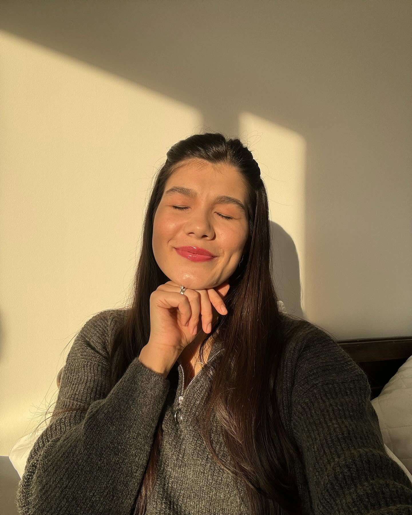 Ileana Sterp făc&acirc;ndu-și un selfie &icirc;n timp ce stă cu ochii &icirc;nchiși &icirc;n razele soarelui și &icirc;și ține una dintre m&acirc;ini sub bărbie