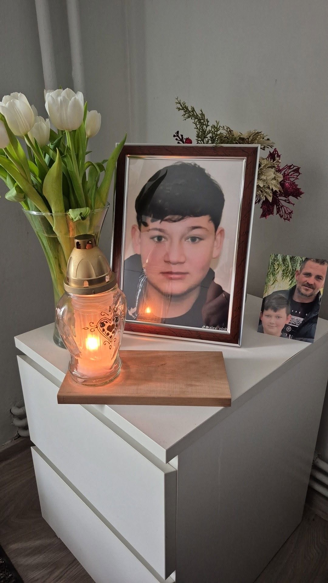 Fotografia lui Mario Berinde așezată pe o noptieră, l&acirc;ngă o altă poză cu el și tatăl său și l&acirc;ngă o candelă aprinsă și două vaze cu flori