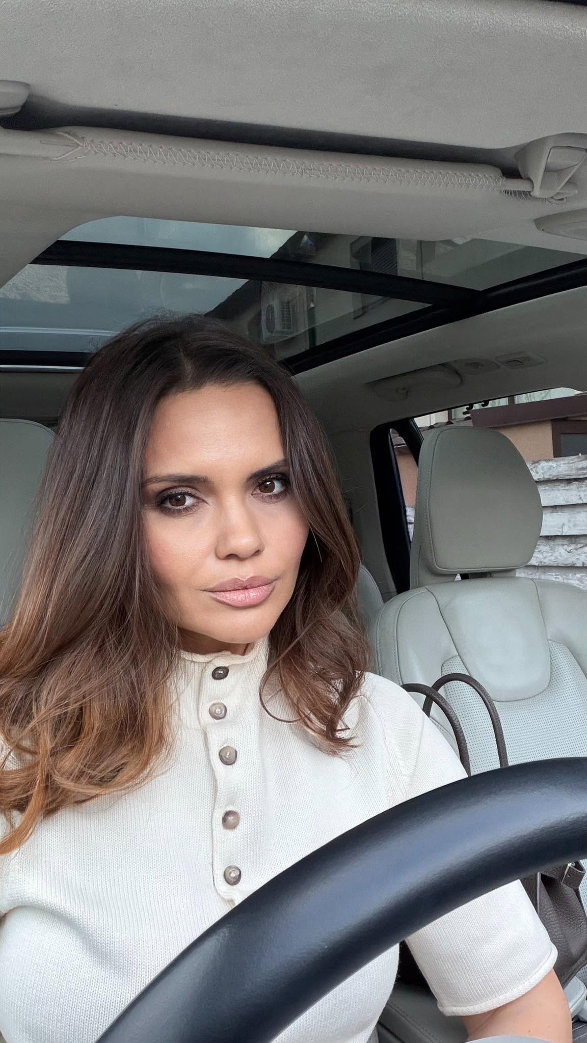 Cristina Șișcanu făc&acirc;ndu-și un selfie &icirc;n mașină, pe scaunul șoferului, cu volanul &icirc;n cadru, purt&acirc;nd un tricou bej cu nasturi și un machiaj natural