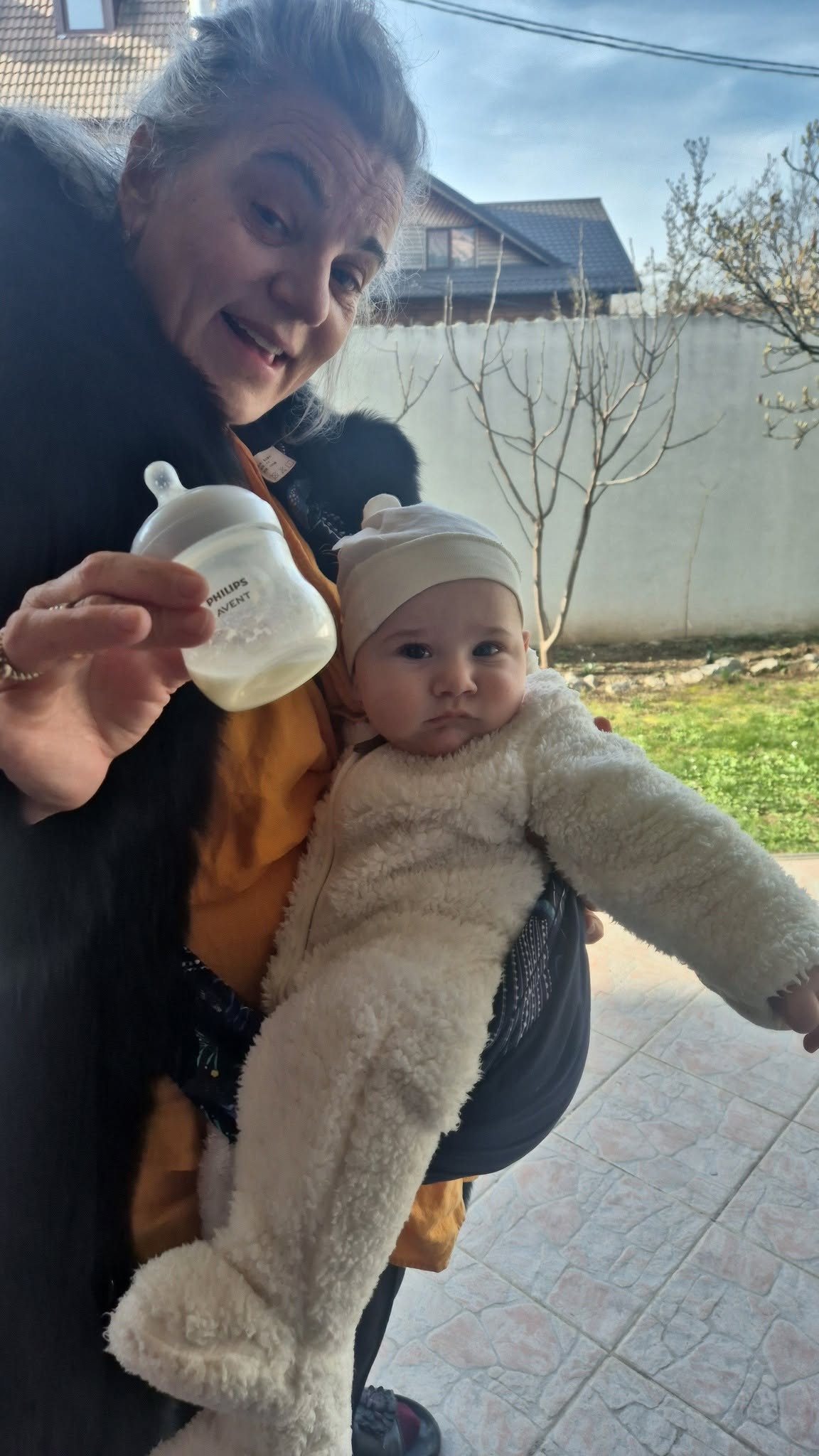 Maia Morgenstern z&acirc;mbitoare, țin&acirc;ndu-și nepotul &icirc;n brațe, &icirc;n timp ce ține &icirc;ntr-o m&acirc;nă și biberonul acestuia
