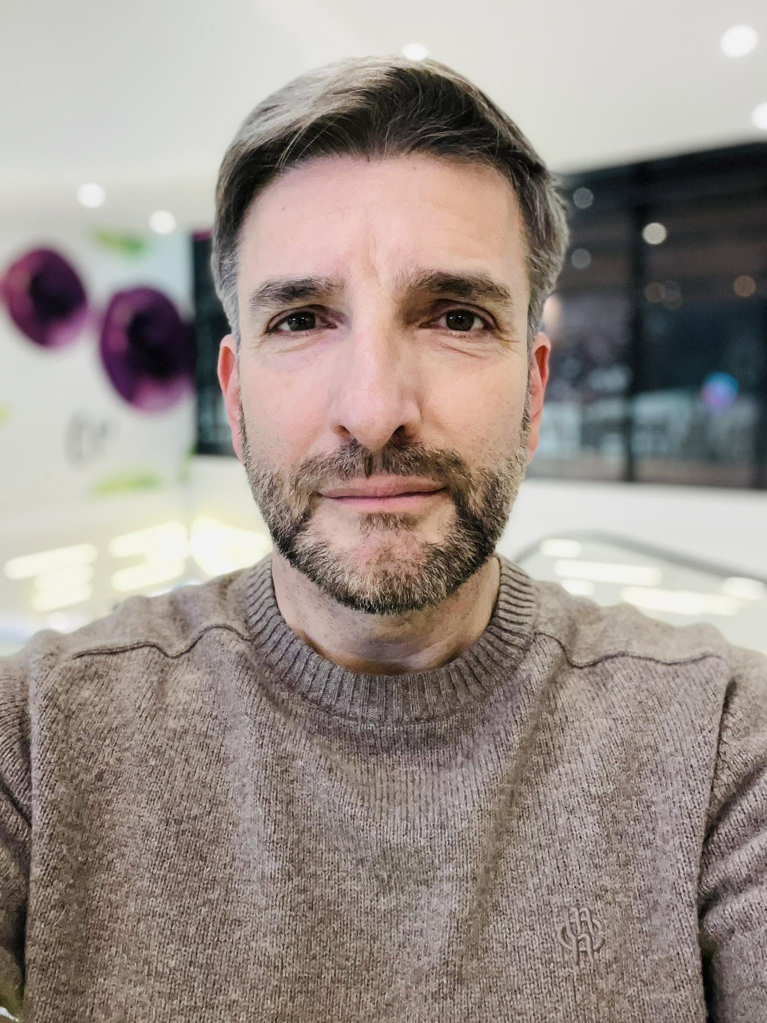 Silviu Biriș serios, făc&acirc;ndu-și un selfie, privind profund spre obiectivul camerei, &icirc;n timp ce era &icirc;mbrăcat &icirc;ntr-un pulover gri