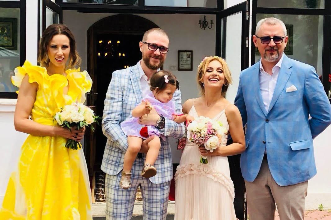 Simona Gherghe mireasă, alături de soțul ei mire, care o ținea în brațe pe fiica lor, Ana, în timp ce lângă ei stăteau nașii lor, Ionela Năstase și Vlad Petreanu