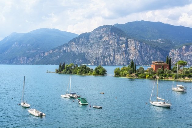 Mai multe bărci pe Lacul Garda din Italia, care este înconjurat de munți