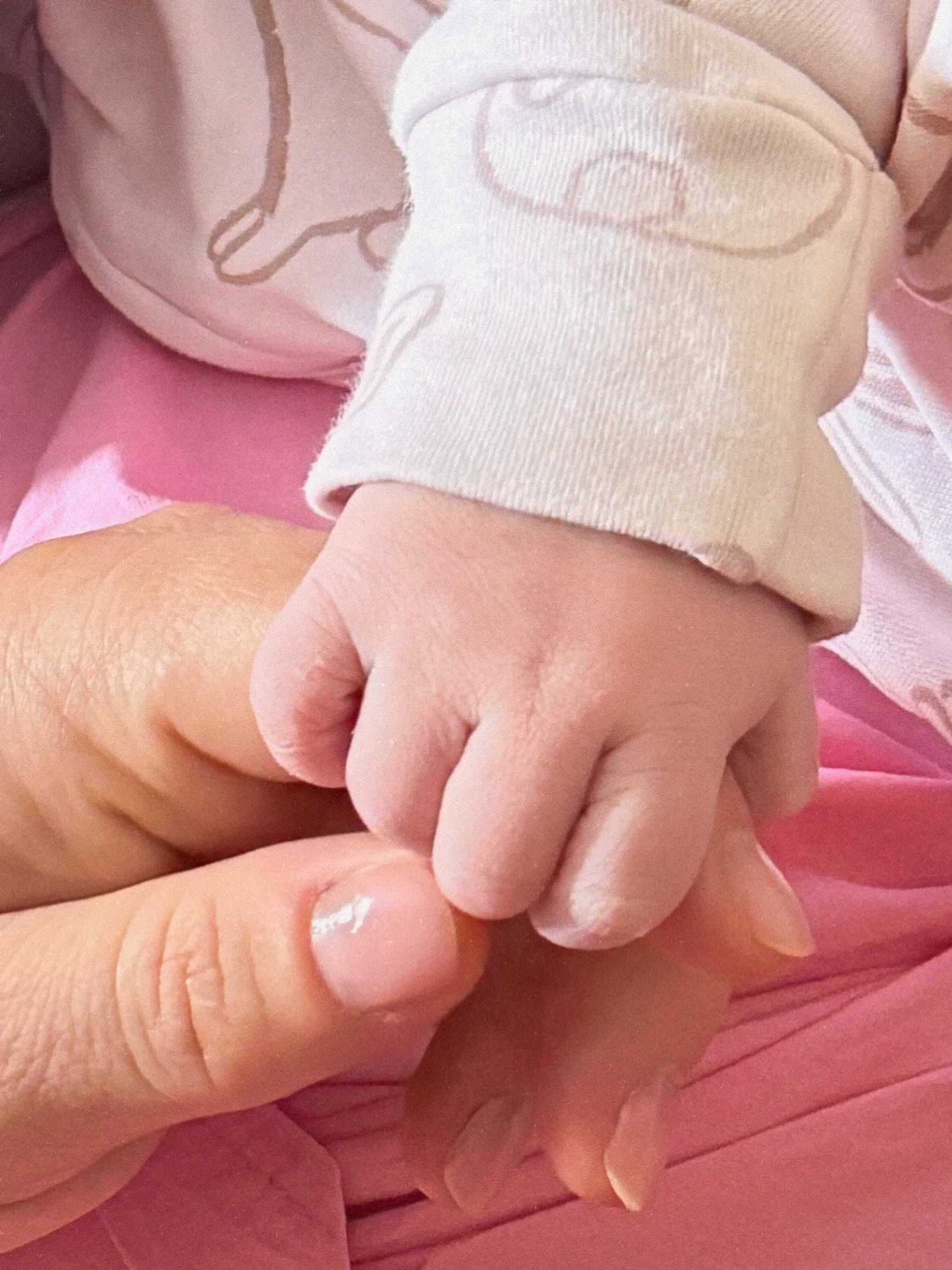 Mâna Laurei Cosoi ținând mâna fiicei sale nou-născute, Nina