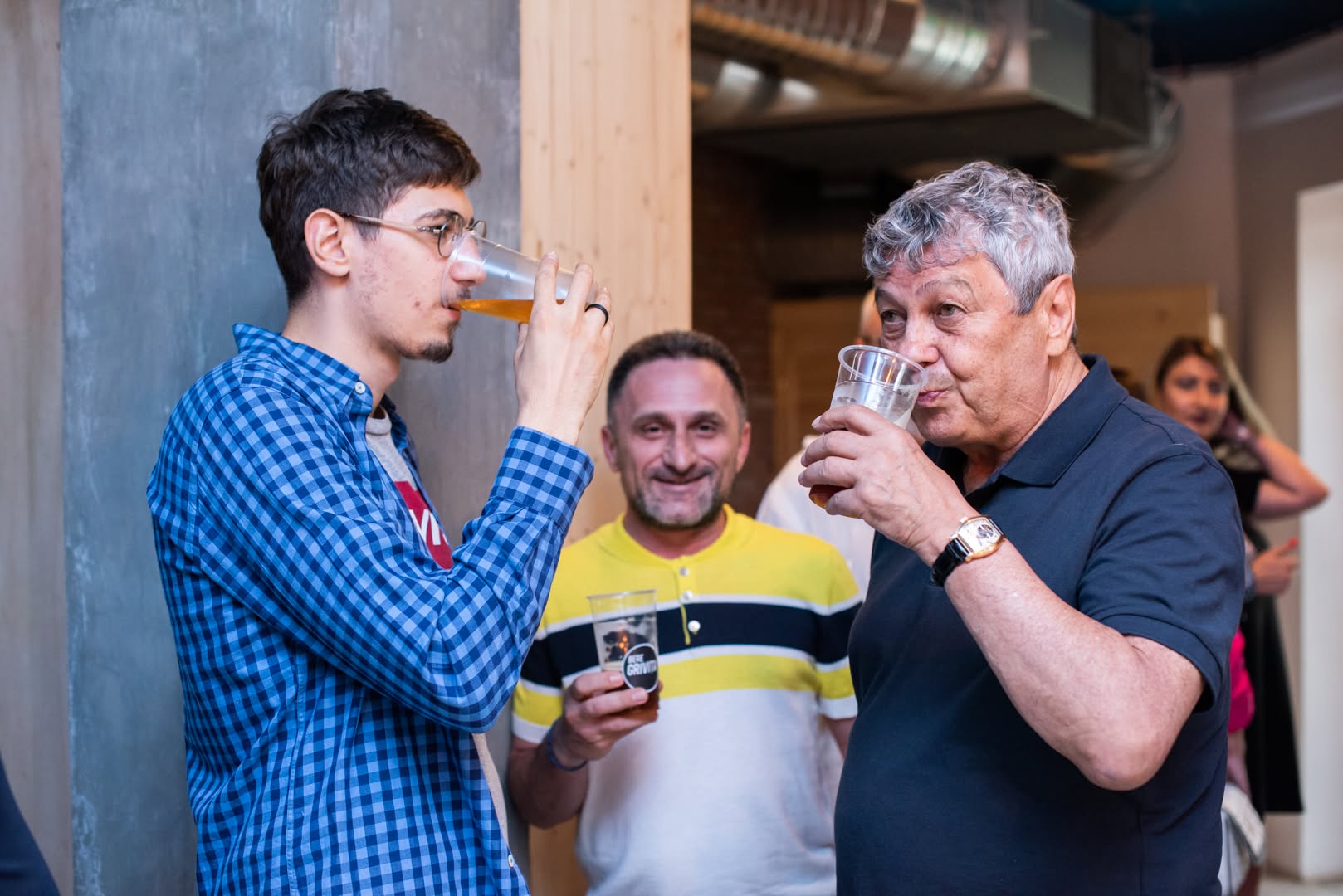 Matei Lucescu alături de Mircea Lucescu, &icirc;n timp ce beau am&acirc;ndoi bere din pahare de plastic