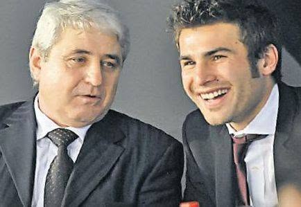 Adrian Mutu z&acirc;mbitor, alături de tatăl său, Spiridon Mutu, &icirc;n timp ce purtau am&acirc;ndoi costume negre și cravate &icirc;nchise la culoare