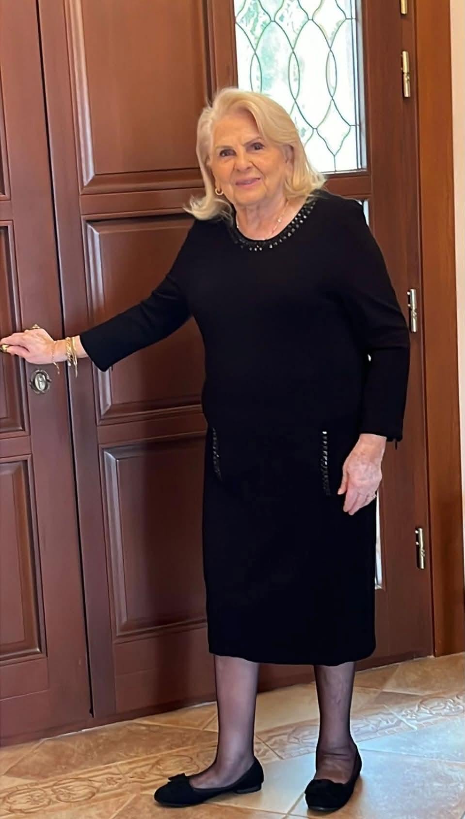Ana Lupescu, mama lui Ionuț Lupescu, țin&acirc;nd m&acirc;na pe clanța unei uși, &icirc;n timp ce era &icirc;mbrăcată &icirc;ntr-o rochie neagră, cu părul blond, tuns p&acirc;nă la umeri