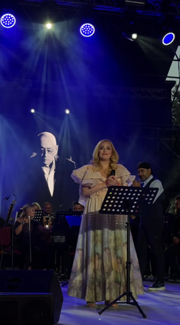 Nidia Moculescu pe scenă, cu fotografia tatălui său &icirc;n spate, pe un ecran imens, &icirc;n timp ce &icirc;i c&acirc;nta piesele