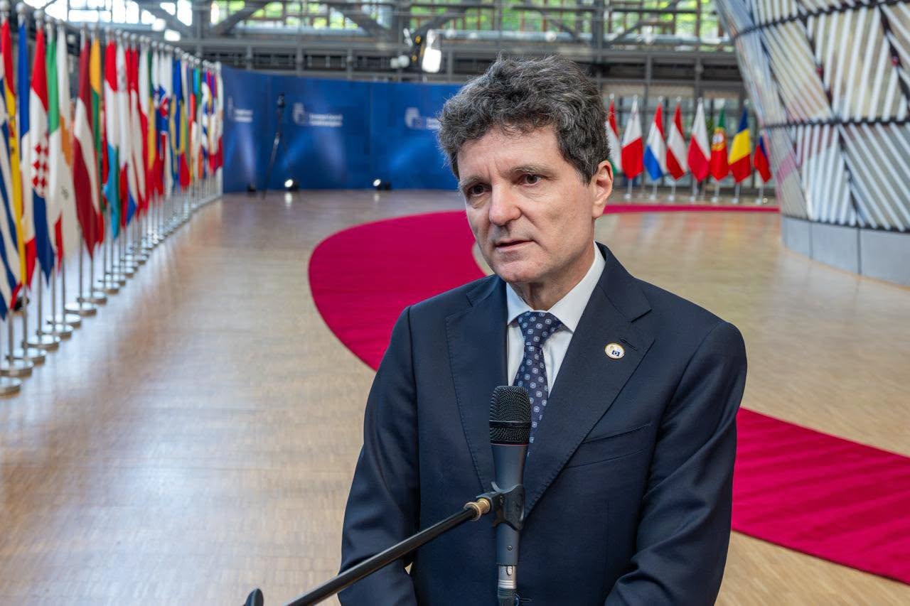 Președintele Nicușor Dan &icirc;n cadrul unei &icirc;nt&acirc;lniri oficiale, vorbind la microfon, &icirc;n timp ce &icirc;n spatele lui se aflau mai multe steaguri ale țărilor din Uniunea Europeană