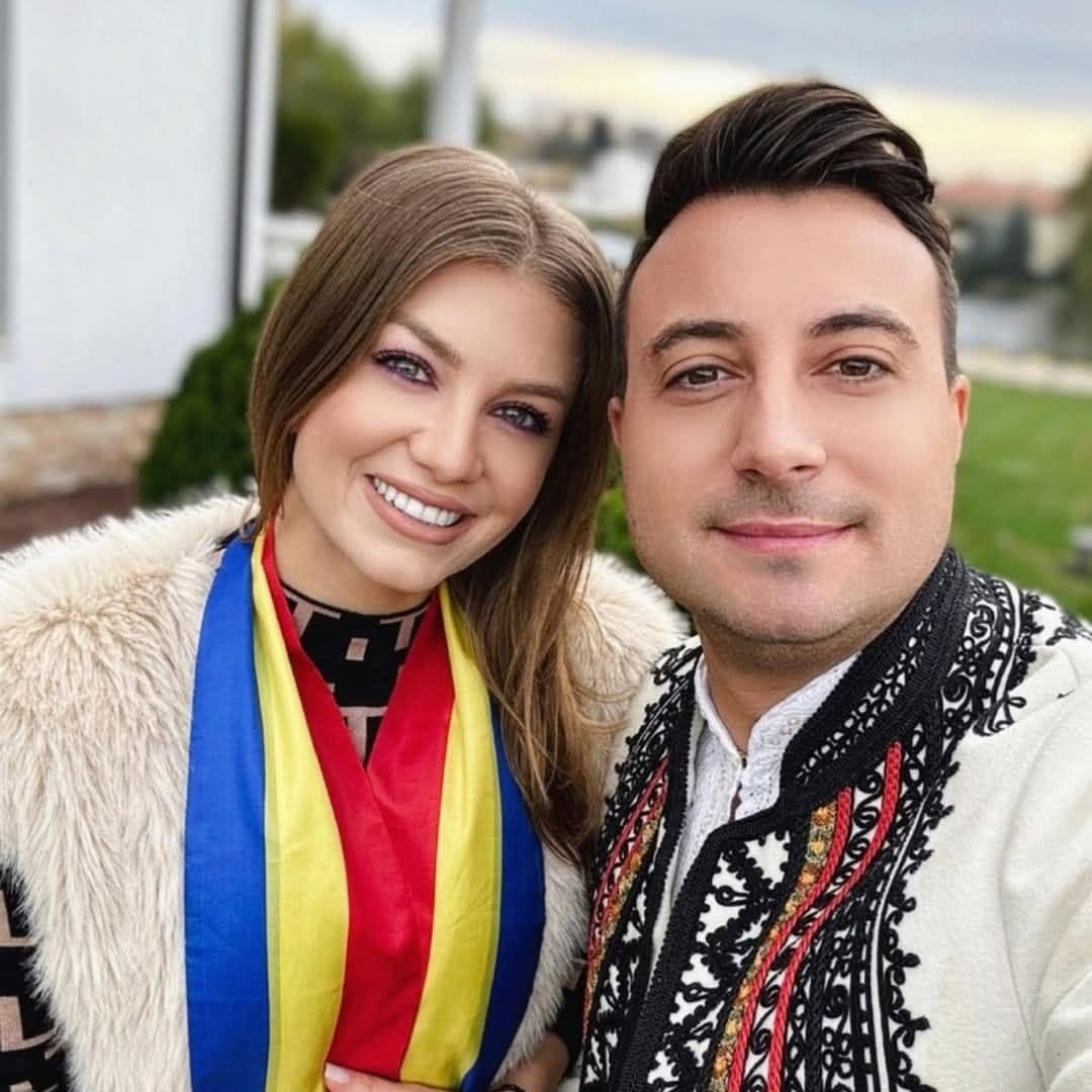 Codruța Filip și Valentin Sanfira &icirc;mbrăcați &icirc;n straie populare, &icirc;n timp ce ea purta la g&acirc;t o eșarfă tricoloră