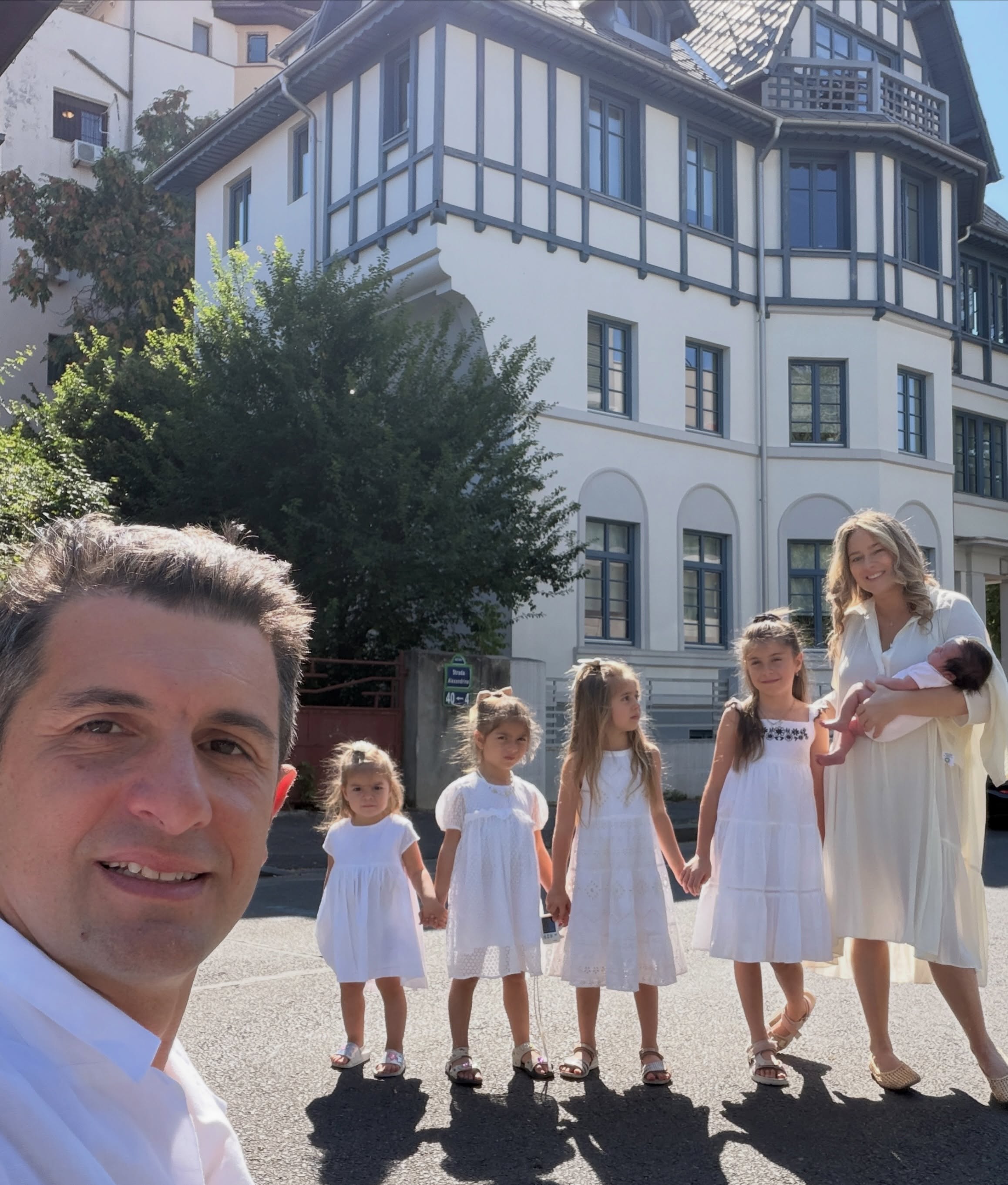 Cosmin Curticăpean făc&acirc;nd un selfie &icirc;n timp ce &icirc;n spatele lui stăteau Laura Cosoi și cele cinci fiice ale lor, după ce s-au &icirc;mbrăcat toți &icirc;n alb