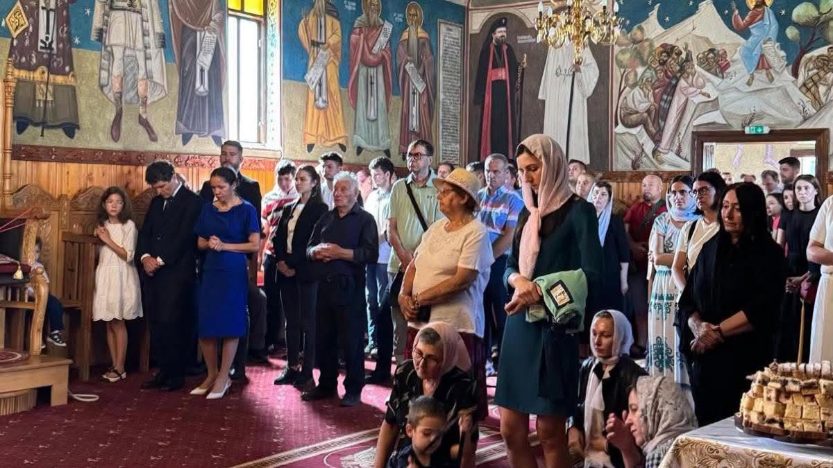 Nicușor Dan rug&acirc;ndu-se &icirc;n biserică, &icirc;mbrăcat &icirc;n costum, alături de Mirabela Grădinaru, &icirc;ntr-o rochie albastră, și de copiii lor, Aheea &icirc;n rochie albă și Antim &icirc;n pantaloni și cămașă