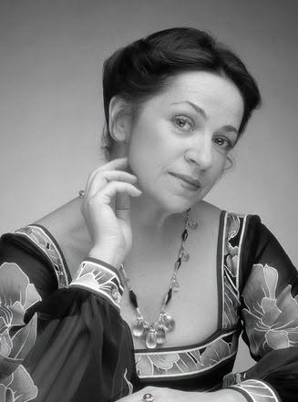 Imagine alb-negru cu soprana Ileana&nbsp;Cotrubaș, &icirc;mbrăcată &icirc;ntr-o rochie &icirc;nchisă la culoare cu imprimeu floral, st&acirc;nd cu o m&acirc;nă &icirc;ndoită pe masă și cu una ridicată la bărbie, &icirc;n timp ce avea părul prins &icirc;ntr-un coc la spate și un colier de mari dimensiuni