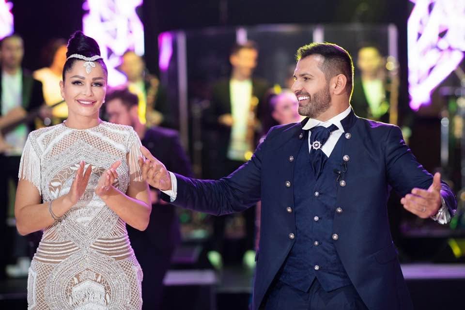 Brigitte Pastramă și soțul ei, Florin Pastramă, pe ringul de dans la o petrecere, dans&acirc;nd &icirc;mpreună, ea &icirc;n rochie albă și el &icirc;n costum bleumarin