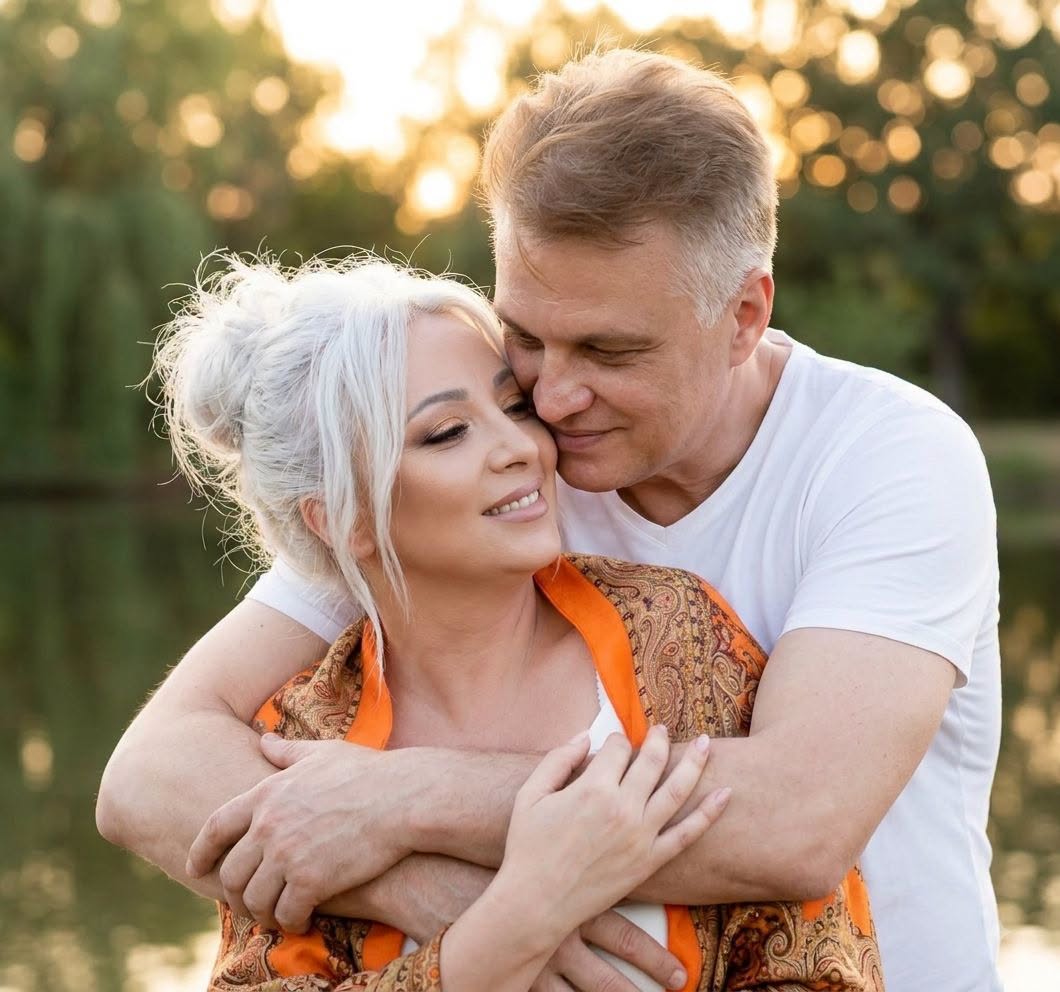 Mihai Onilă țin&acirc;nd-o &icirc;n brațe pe soția sa, Laura Onilă, care poartă un șal colorat pe umeri