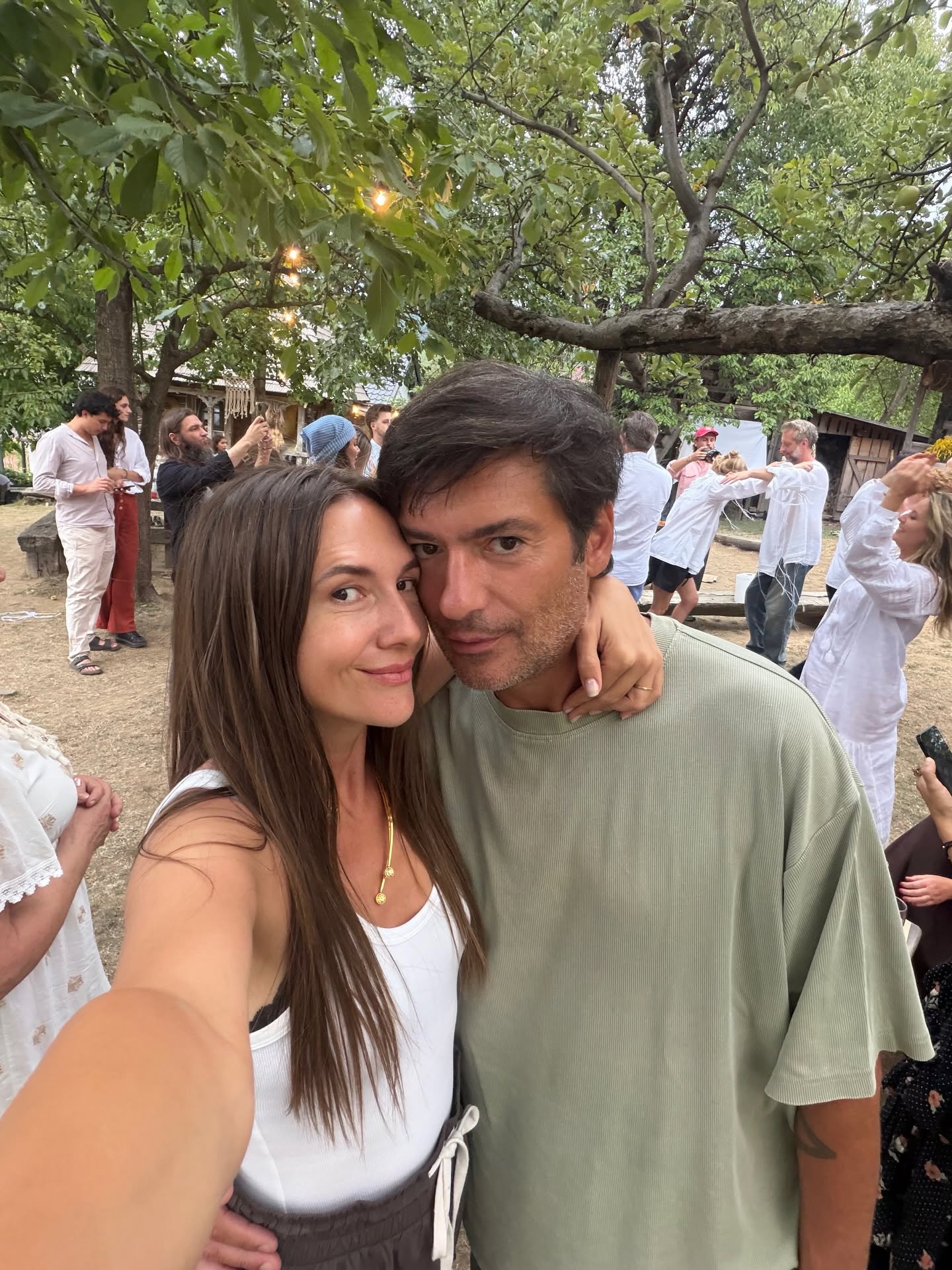 Adela Popescu țin&acirc;nd-l de g&acirc;t pe Radu V&acirc;lcan, la o petrecere &icirc;n aerl liber la care oamenii sunt &icirc;mbrăcați mai mult &icirc;n alb și culori neutre